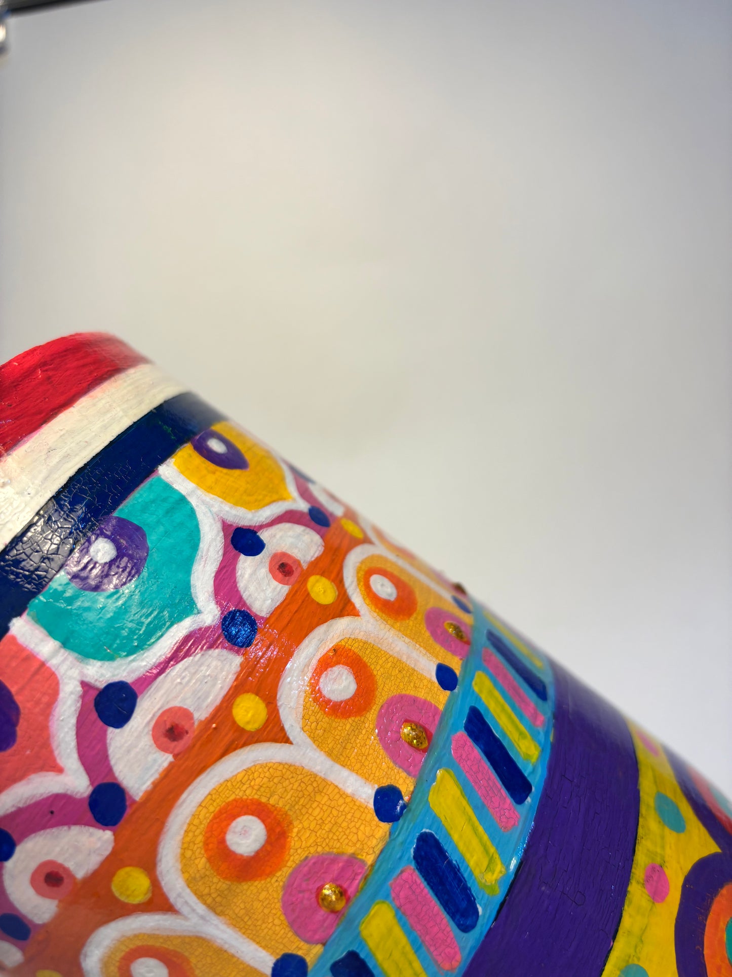 Colorful ceramic vase with abstract patterns on a white background