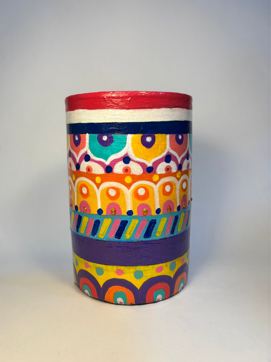 Colorful cylindrical vase with geometric pattern on a white background
